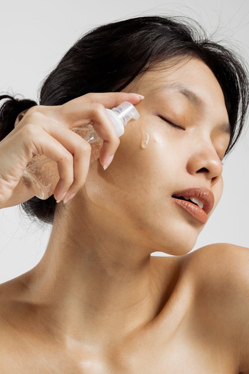 Woman Applying Cosmetic on Face from Spray Bottle